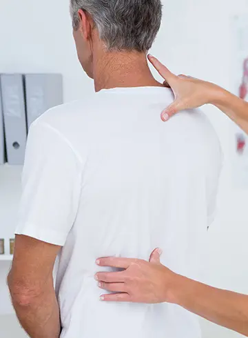 chiropractor looking at male patients back