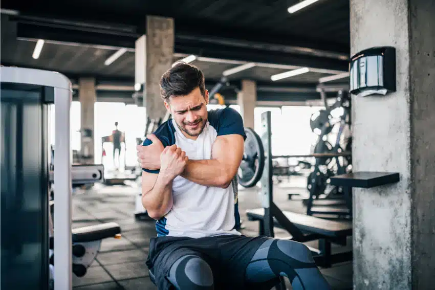 Man suffers from muscle strain while doing some fitness exercise at fitness facility for Sports Injury Treatment in West Omaha