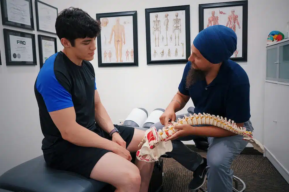 Chiropractor having an assessment with a patient that suffers from sports injury 